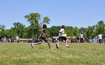 two kids running with a frisbee