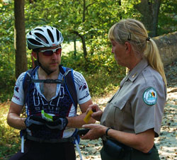 A ranger at Fair Hill assists a cyclist
